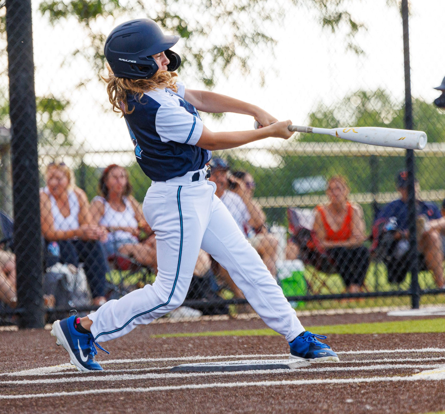 Baseball player in action during a game with spectators in the background.