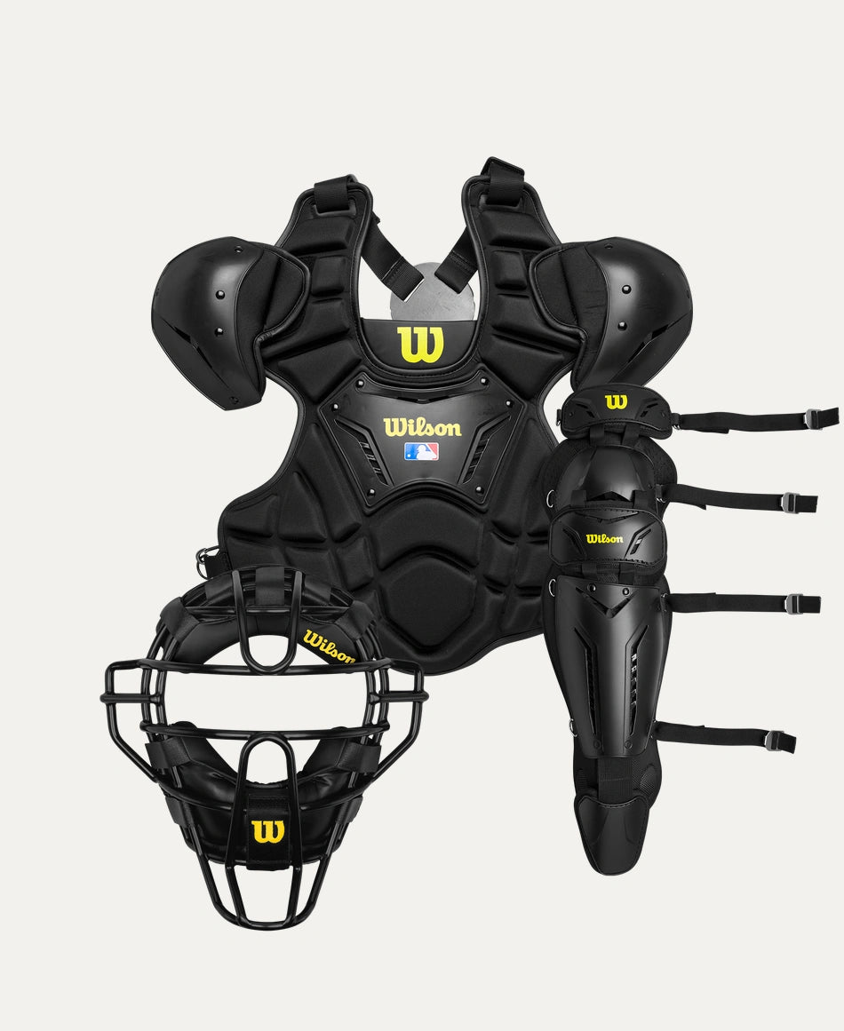 A comprehensive set of black umpire gear including a face mask, chest protector, and leg guards, all branded with the Wilson logo.